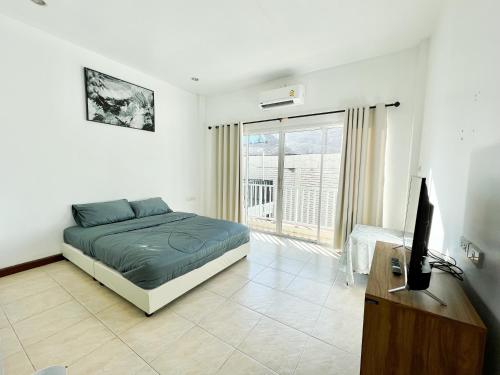 a bedroom with a bed and a television and a desk at Sky&Sea Cha-AM Beach in Cha Am