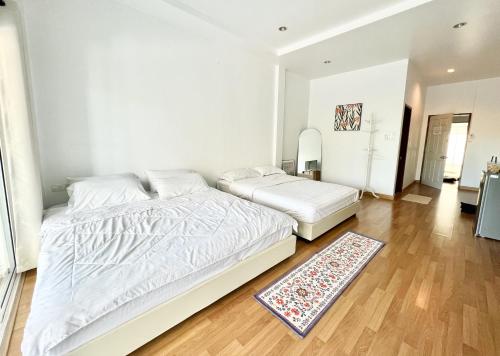a bedroom with a large white bed and a rug at Sky&Sea Cha-AM Beach in Cha Am