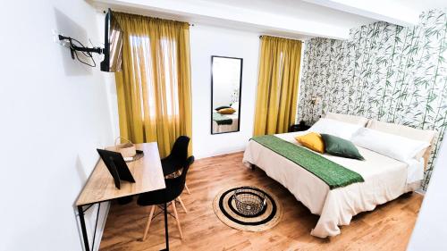 a bedroom with a bed and a table and a desk at Ecorooms Ferrara in Ferrara