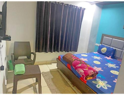 a bedroom with a bed and a chair and a window at Smart Guest House, Panipat in Pānīpat