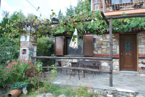 a stone house with a table and a window at Tzivaeri in Likodhrómion
