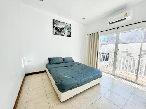 a bedroom with a bed and a large window at Sky&Sea Cha-AM Beach in Cha Am