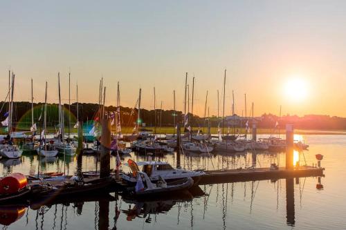 a group of boats docked in a marina at sunset at L'atelier Chic - Wifi fibre - Parking privée - Balcon - NETFLIX in Lanester