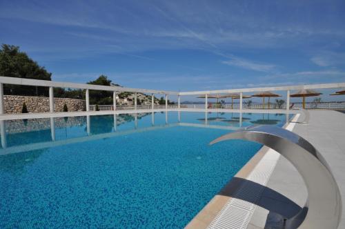 duży basen z błękitną wodą i parasolami w obiekcie Oaza Mira Camping w mieście Drage