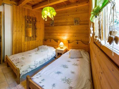 une chambre avec deux lits dans une cabane en rondins dans l'établissement Chalet cosy 6 pers avec SPA, terrasse sud, proche station ski, animaux admis - FR-1-393-16, à Saint-Michel-de-Chaillol