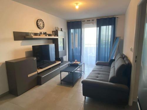 - un salon avec un canapé et une télévision dans l'établissement Jolie T2 dans village provençale, au Luc