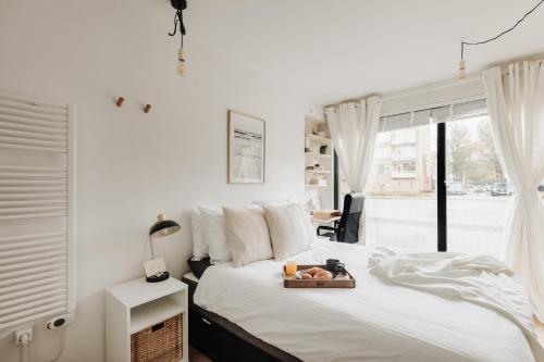 a bedroom with a bed with a tray of food on it at Luxurious Private Studio Amsterdam Zuid in Amsterdam