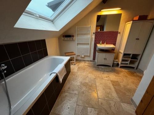 ein Badezimmer mit einer großen Badewanne und einem Waschbecken in der Unterkunft Ferienwohnungen Grundmühle in Nordheim vor der Rhön