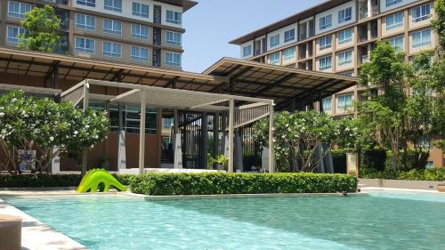 a swimming pool with a slide in front of a building at Blissful beach Cha-am in Cha Am