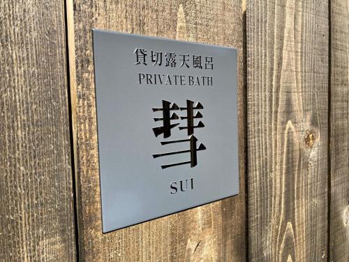 a sign for a private bath on a wooden wall at Urakusatsu TOU in Kusatsu