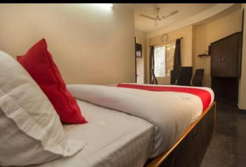 a bedroom with a bed with red and white pillows at Skyline Lodge in Siliguri