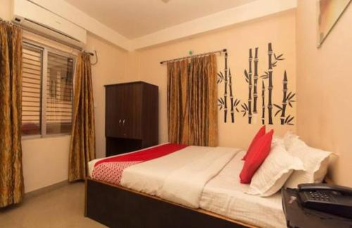 a bedroom with a bed with red pillows at Skyline Lodge in Siliguri