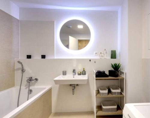 ein weißes Badezimmer mit einem Waschbecken und einem Spiegel in der Unterkunft Klinger apartment in Bratislava