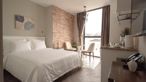 a bedroom with a white bed and a brick wall at Celine Living - Central in Ho Chi Minh City