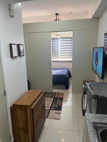 a room with a bedroom with a bed and a mirror at Fully Furnished 1 bedroom Condo Las Pinas in Manila