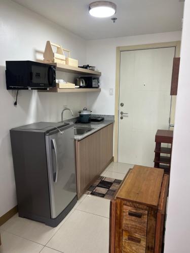 a kitchen with a stainless steel refrigerator and a sink at Fully Furnished 1 bedroom Condo Las Pinas in Manila