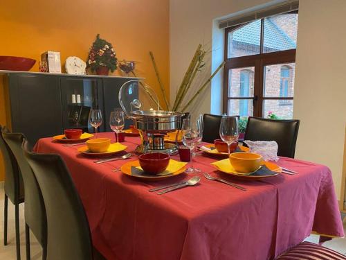 a table with a red table cloth and wine glasses at ChienMarin Healthfarm & Residences Anno 1712 ***** in Nieuwpoort