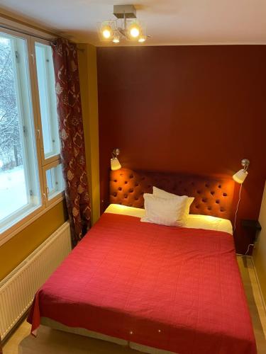 a bedroom with a red bed with a red blanket at Lapin Satu in Posio