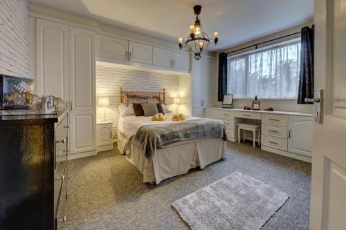 Schlafzimmer mit einem Bett, einem Schreibtisch und einem Fenster in der Unterkunft Harry's House (Muggles welcome too!) in Watford