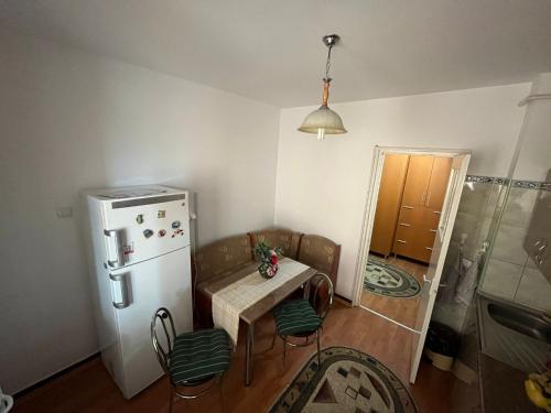 a kitchen with a small table and a refrigerator at Lala's sweet nest in Călimăneşti