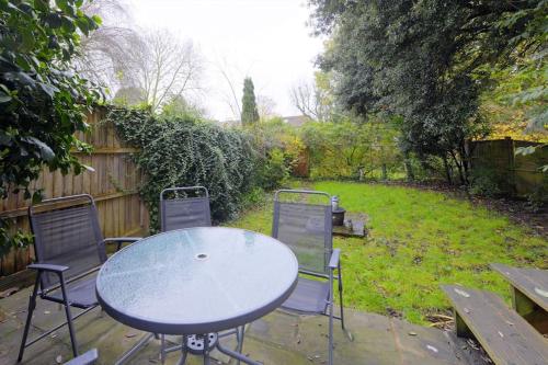 a table and chairs in a backyard with a fence at Harry's House (Muggles welcome too!) in Watford