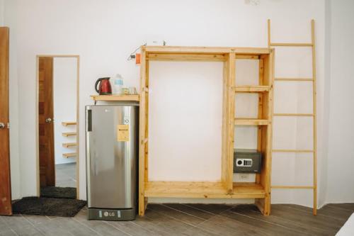 een koelkast in een kamer naast een plank bij johandive in Daanbantayan