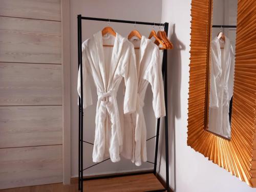 a closet with white coats and a mirror at Suite con Jacuzzi de la Haya, junto al Teatro Romano in Merida