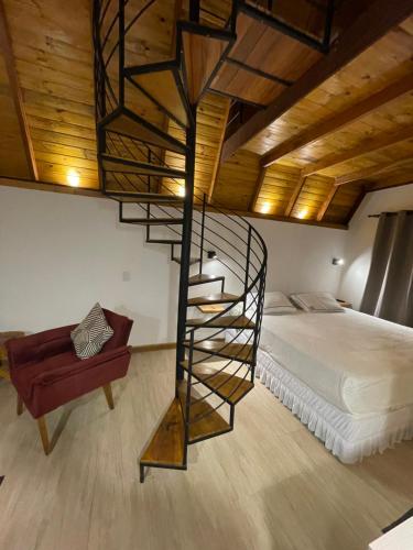 a bedroom with a spiral staircase next to a bed at VILLA ITÁLIA CHALÉ in Santo Antônio do Pinhal