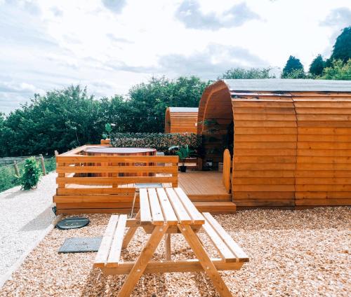 a wooden bench sitting next to a wooden hut at Crabmill Glamping with hot tub in Bewdley
