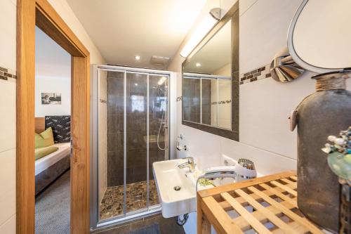 uma casa de banho com um lavatório e um chuveiro em Haus Hochland em Tux