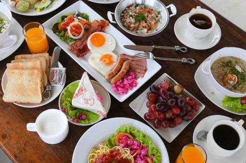 Swiss Valley Hip Resort في سوان فونج: طاولة مع أطباق من طعام ومشروبات الإفطار