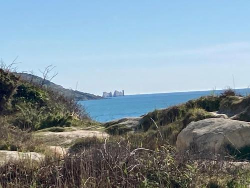 a beach with rocks and the ocean in the background at SEAVIEW self-catering coastal bungalow in rural West Wight in Freshwater