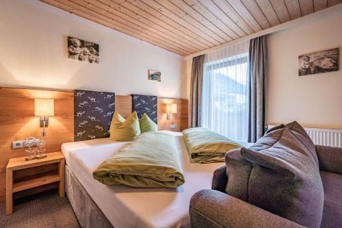 a hotel room with two beds and a couch at Haus Hochland in Tux