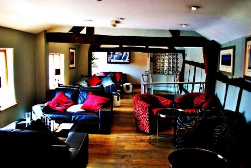 uma sala de estar com sofás e almofadas vermelhas em Cheshire Cat em Nantwich