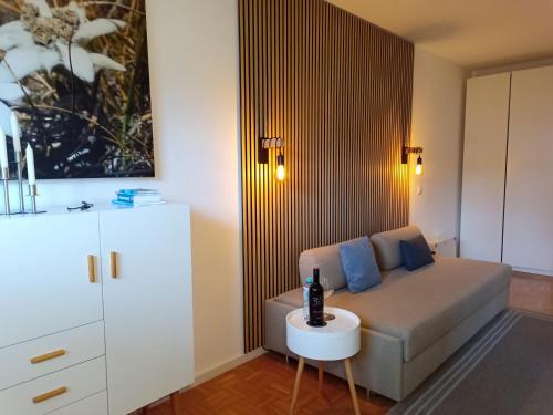 uma sala de estar com um sofá e uma mesa em Cosy little apartment em Munique