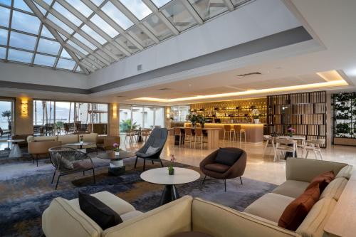 een lobby met banken en stoelen en een bibliotheek bij Aria in Eilat