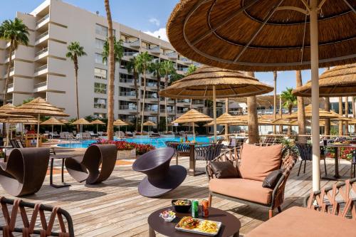 a resort with a pool and chairs and umbrellas at Aria in Eilat