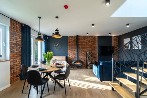 a dining room and living room with a table and chairs at Family Resort Ustka - Domki dwupoziomowe z basenem in Ustka