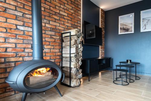a fireplace in a room with a brick wall at Family Resort Ustka - Domki dwupoziomowe z basenem in Ustka