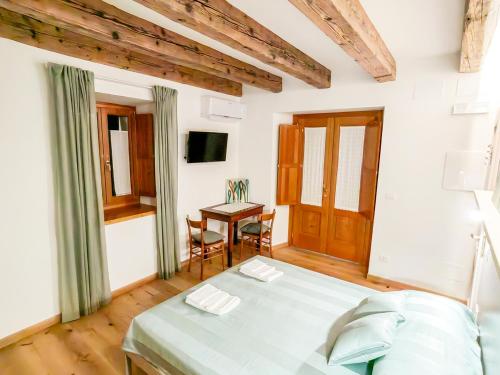 a bedroom with a bed and a table in a room at Home Dren in Prepotto