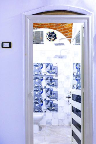 a bathroom with a toilet and a wall of shoes at Onaty Ka Guest House in Aswan