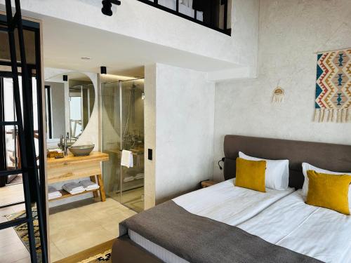 a bedroom with a bed with yellow pillows and a bathroom at Chalet CrepDeChine Hotel in Bukovel