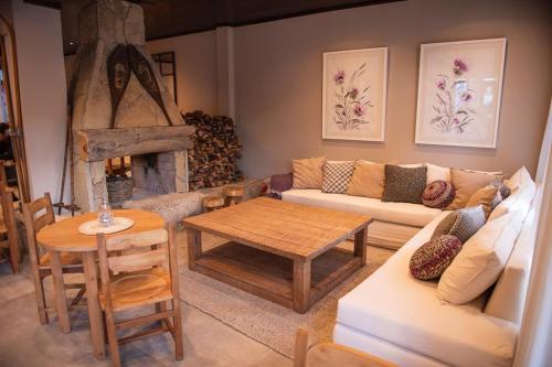 a living room with a couch and a table and a fireplace at Tunqueley Hotel in San Martín de los Andes