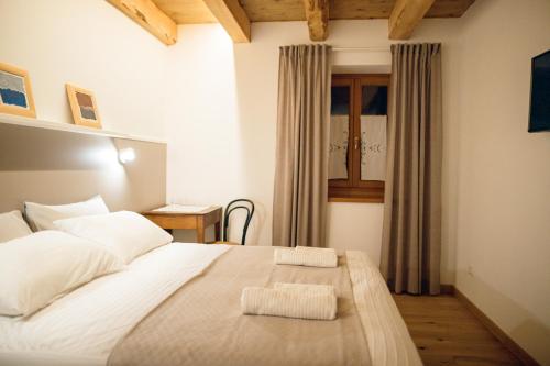 a bedroom with a large white bed and a window at Home Dren in Prepotto
