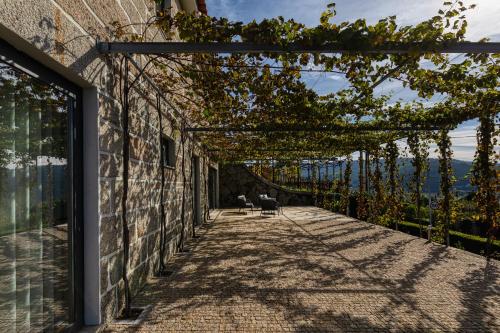 einen Gehweg zu einem Haus mit einer Pergola in der Unterkunft Casa do Soutinho in Alvarenga