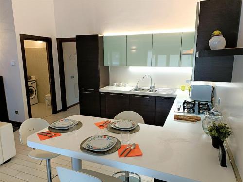 een keuken met een tafel met borden erop bij Bareggio Comfort Apartment in Bareggio