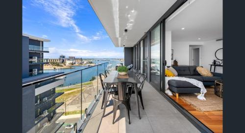 a room with a balcony with a view of the ocean at 3 Bedroom Sub Penthouse Apartment in the heart of Newcastle in Wickham