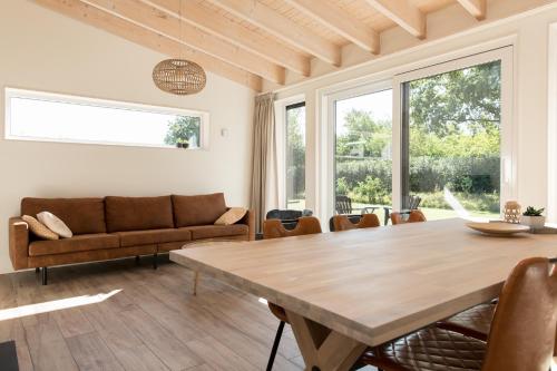a living room with a table and a couch at Vakantiehuis Eikzicht gelegen aan het bos in Elsloo