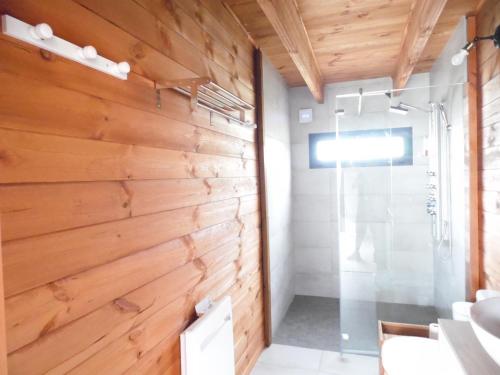 a bathroom with a wooden wall and a shower at Chalet cosy climatisé avec parking et Internet in Doué-la-Fontaine