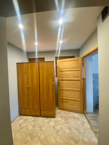 a room with wooden cabinets and lights on the ceiling at Pokoje z własnymi aneksami kuchennymi - Zbigniew Lassak in Biały Dunajec